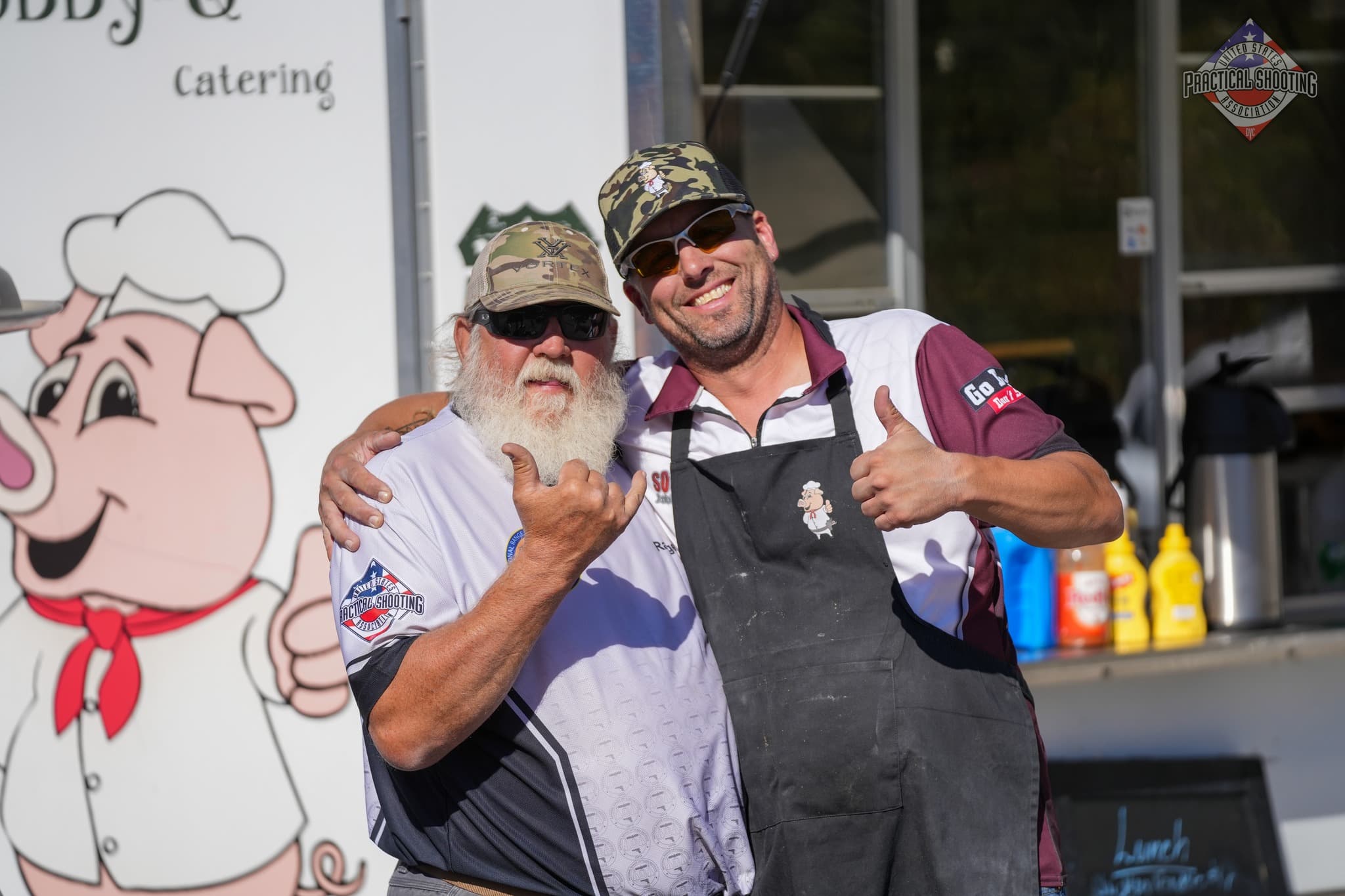 Group of USPSA shooters sharing tips and building community at a match